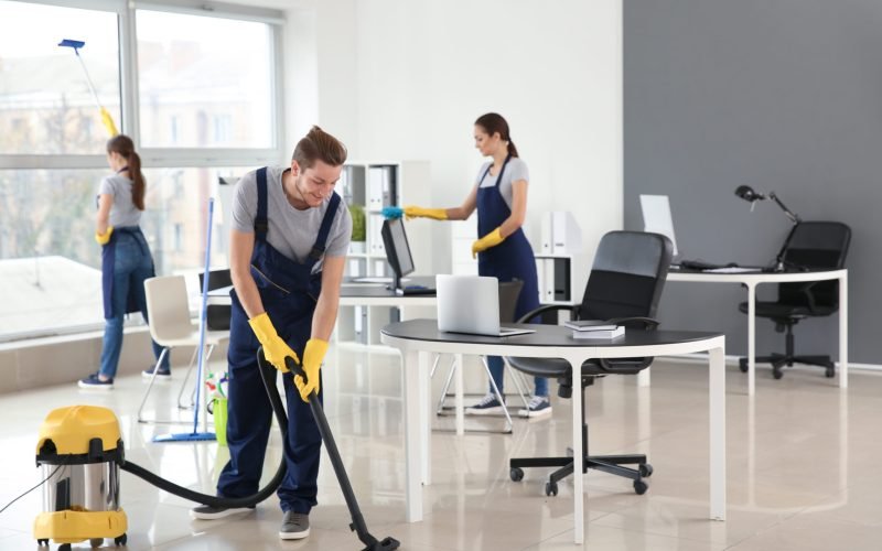 Team of janitors cleaning office
